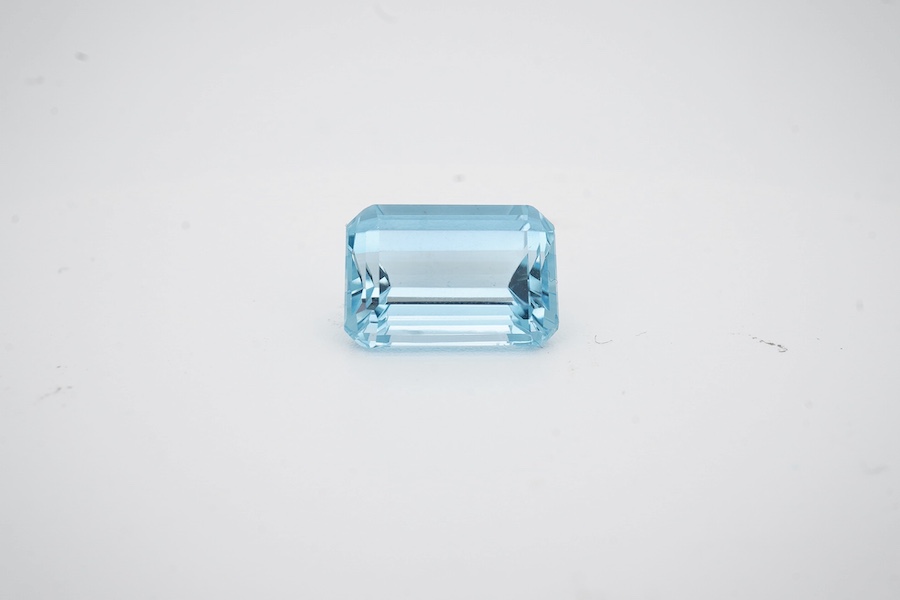 An unmounted emerald cut aquamarine, weighing approximately 6.00ct, in a fitted gilt tooled leather box by Francelino Horta Junior, Rio De Janeiro. Condition - fair to good